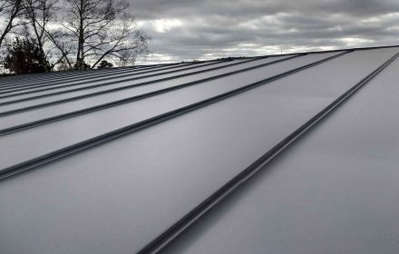 Close-up detail of house roof made from gray metal sheets.