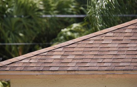 Closeup of house roof top covered with asphalt or bitumen shingles. Waterproofing of new building.