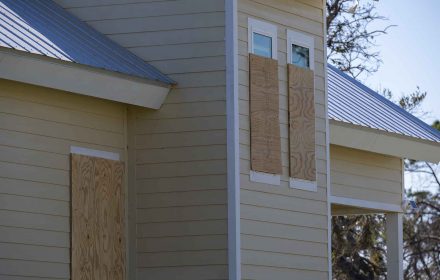 Plywood storm shutters for hurricane protection of house windows. Protective measures before natural disaster in Florida.